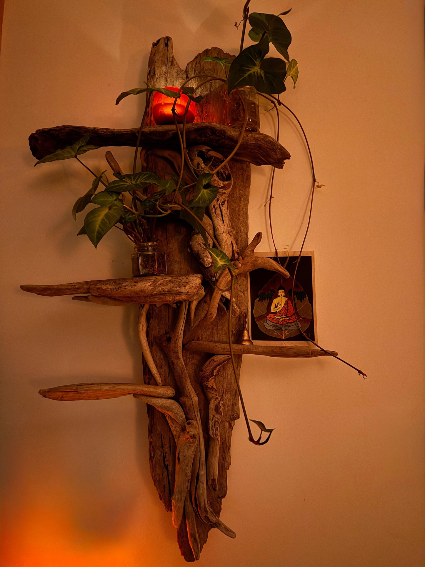Sculpture made of driftwood, wall hanging, candle and image of Buddha to symbolise the title of the blog: Embracing Eco-Art Therapy for Climate Anxiety - showing resilience and peace 