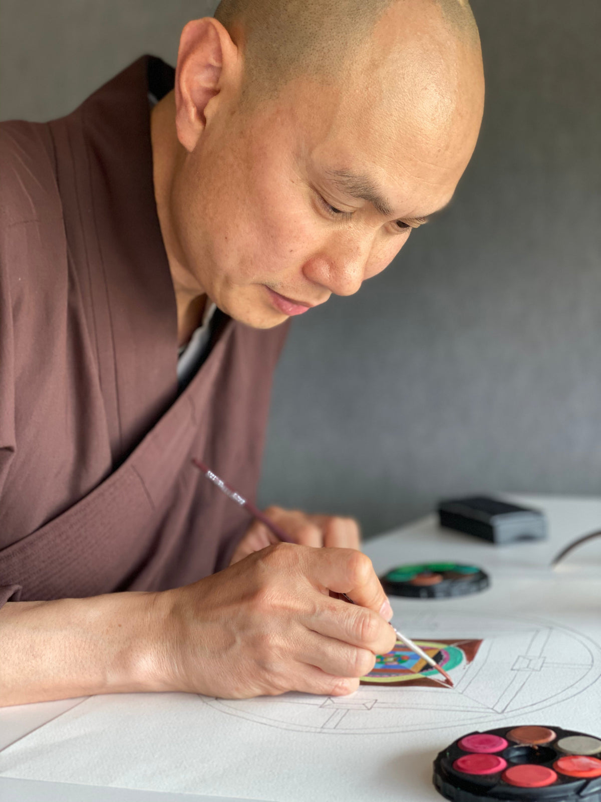 Buddhist monk drawing a mandala at CECAT's art therapy course