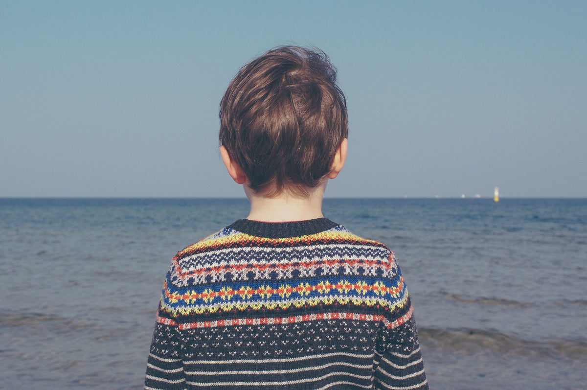Young boy looking at the ocean