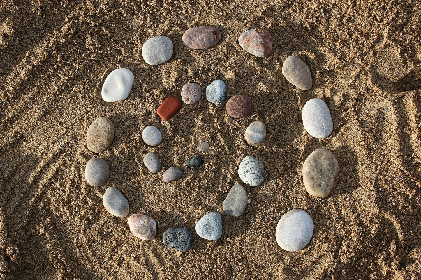 How Art Therapy Rebuilds the Traumatised Brain, stones in a spiral on the sand