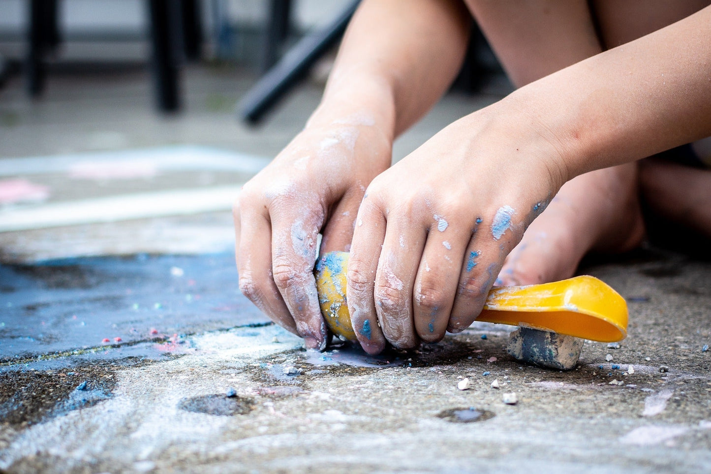 Art Therapy and Children - young hands working with coloured chalk on the ground